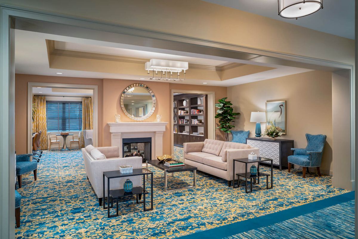 A modern living room with elegant furnishings, featuring a fireplace and plush sofas.