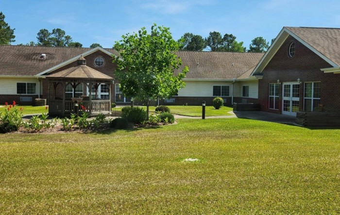 A view of a residential building with a well-maintained garden and spacious lawn.
