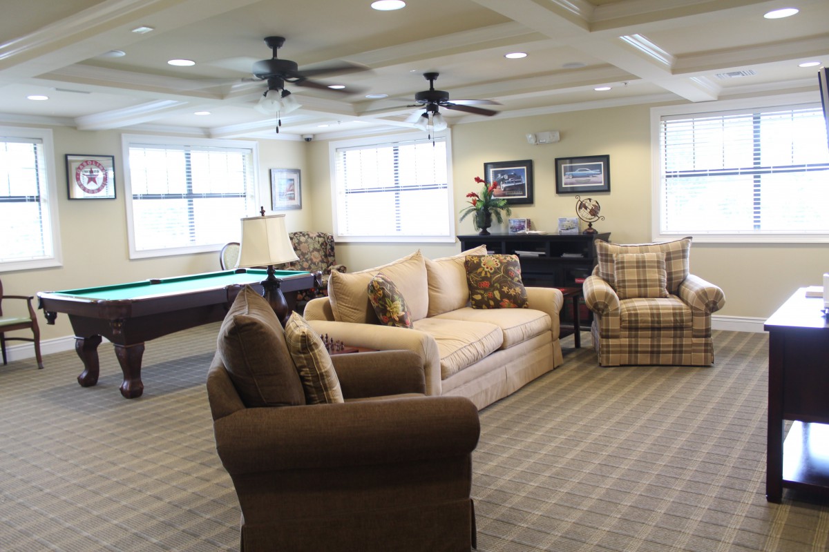 A cozy living room with sofas and a pool table.