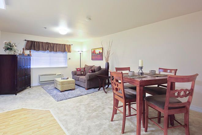 A cozy living and dining space with a sofa, table, and chairs, accented by home decor.