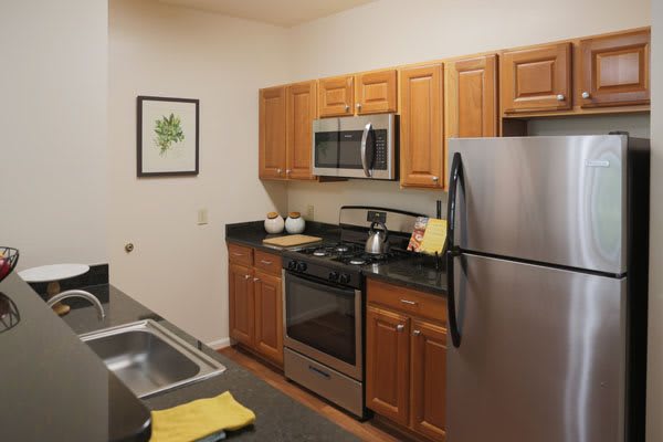 A modern kitchen with wooden cabinets and stainless steel appliances.
