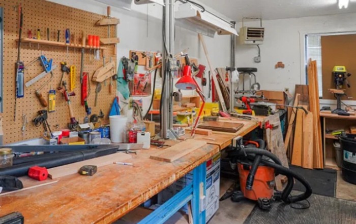 A well-equipped woodworking workshop featuring a variety of tools and machinery on a workbench.