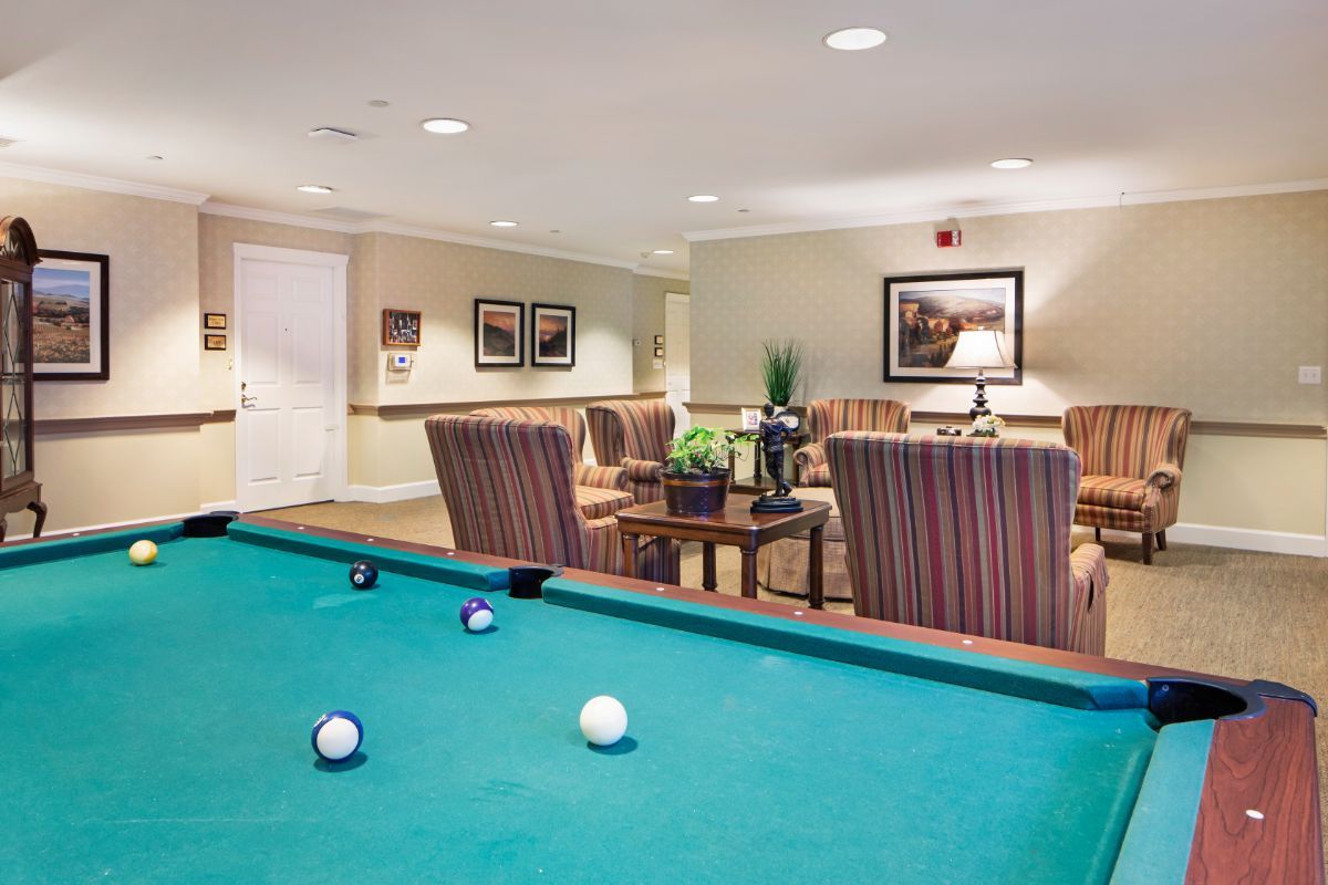 A cozy game room featuring a billiards table and comfortable seating.