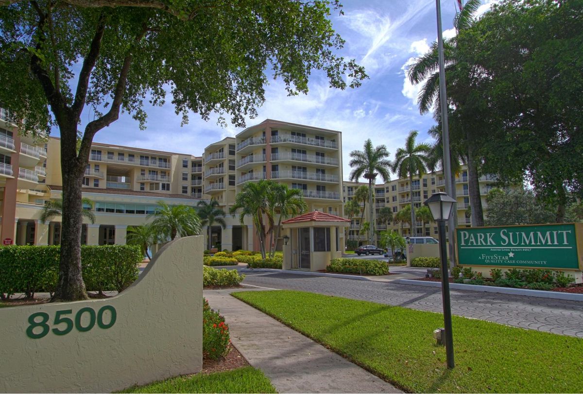 Entrance to a residential apartment complex with palm trees.
