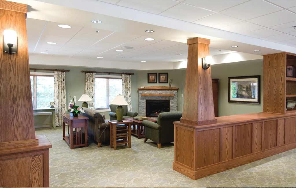 A cozy living room with comfortable sofas, a fireplace, and wooden decor.