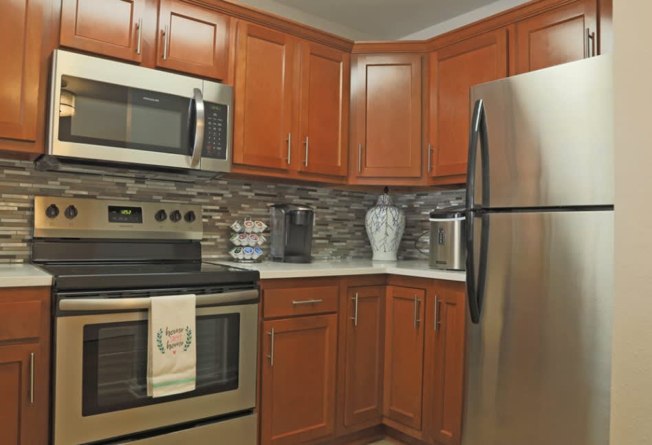 A modern kitchen featuring stainless steel appliances and wooden cabinetry.