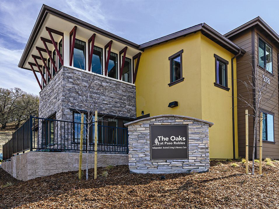 A modern clubhouse building with a stone facade and yellow accents.