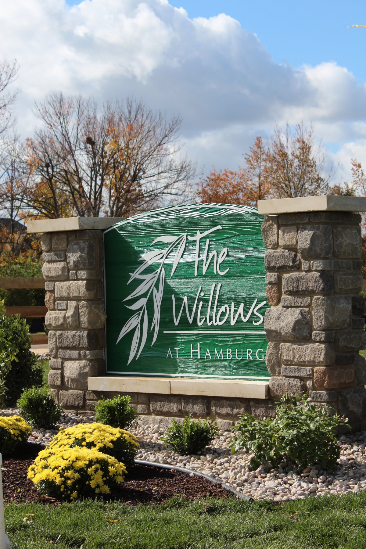 Entrance sign for The Willows at Hamburg surrounded by autumn foliage.