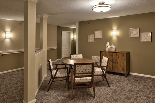 A cozy and modern dining area featuring a wooden table surrounded by comfortable chairs, set in a warm-toned interior.
