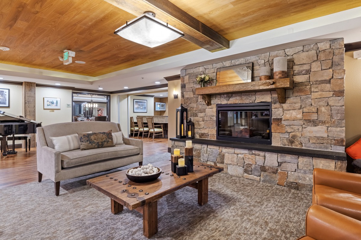 A cozy living room featuring a stone fireplace and modern wooden accents.