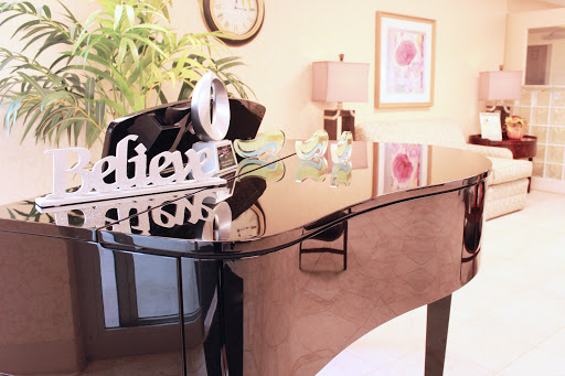 A beautifully arranged living room featuring a glossy piano and tasteful decorations.