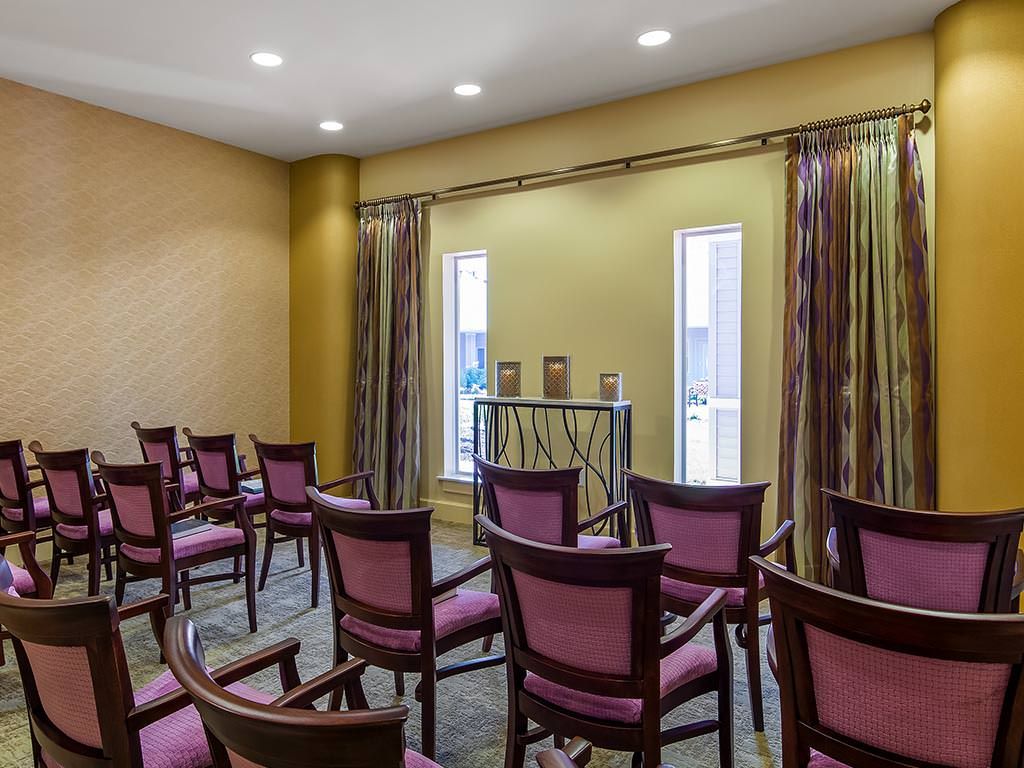 A small meeting room with rows of chairs arranged for a presentation or event.