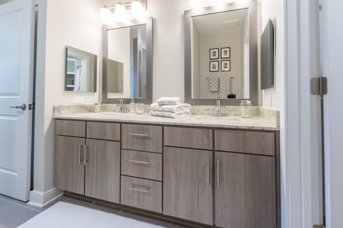 A modern bathroom with a double vanity, large mirrors, and contemporary lighting.