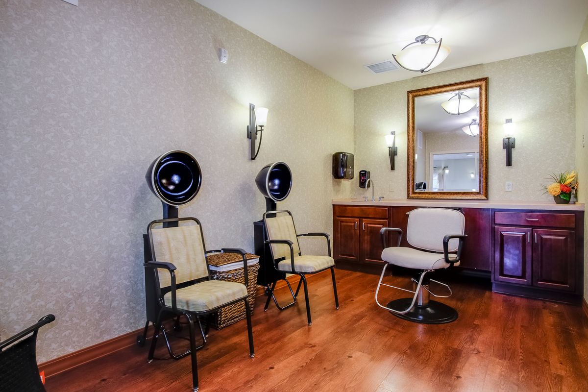 An inviting hair salon interior featuring styling chairs, hair dryers, and a large mirror.