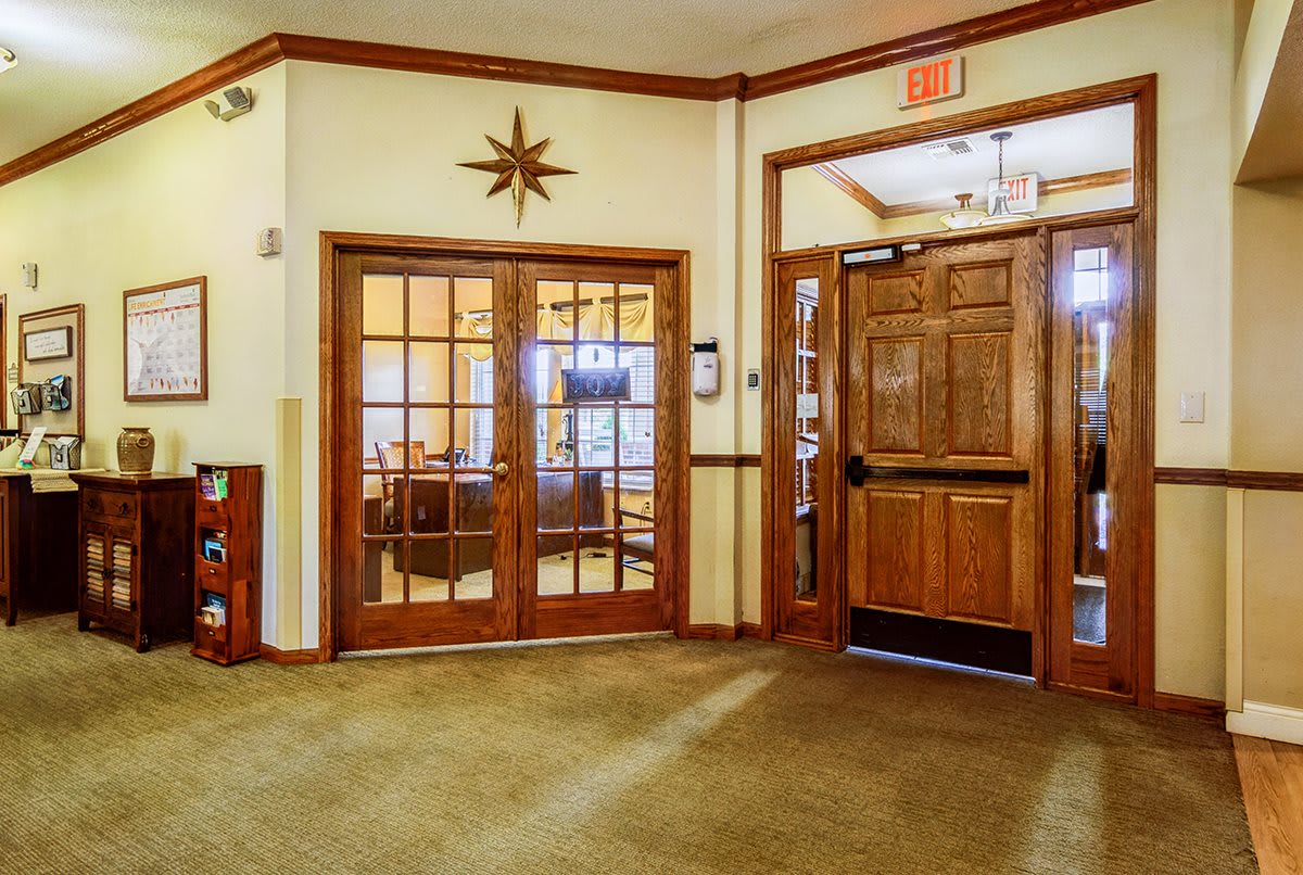 A warm and inviting lobby area with wooden double doors and a decorative wall feature.