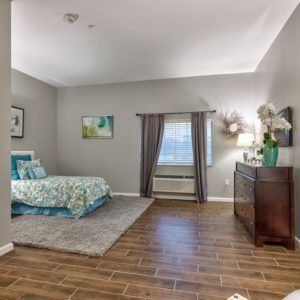 A modern bedroom with wood flooring and stylish decor.