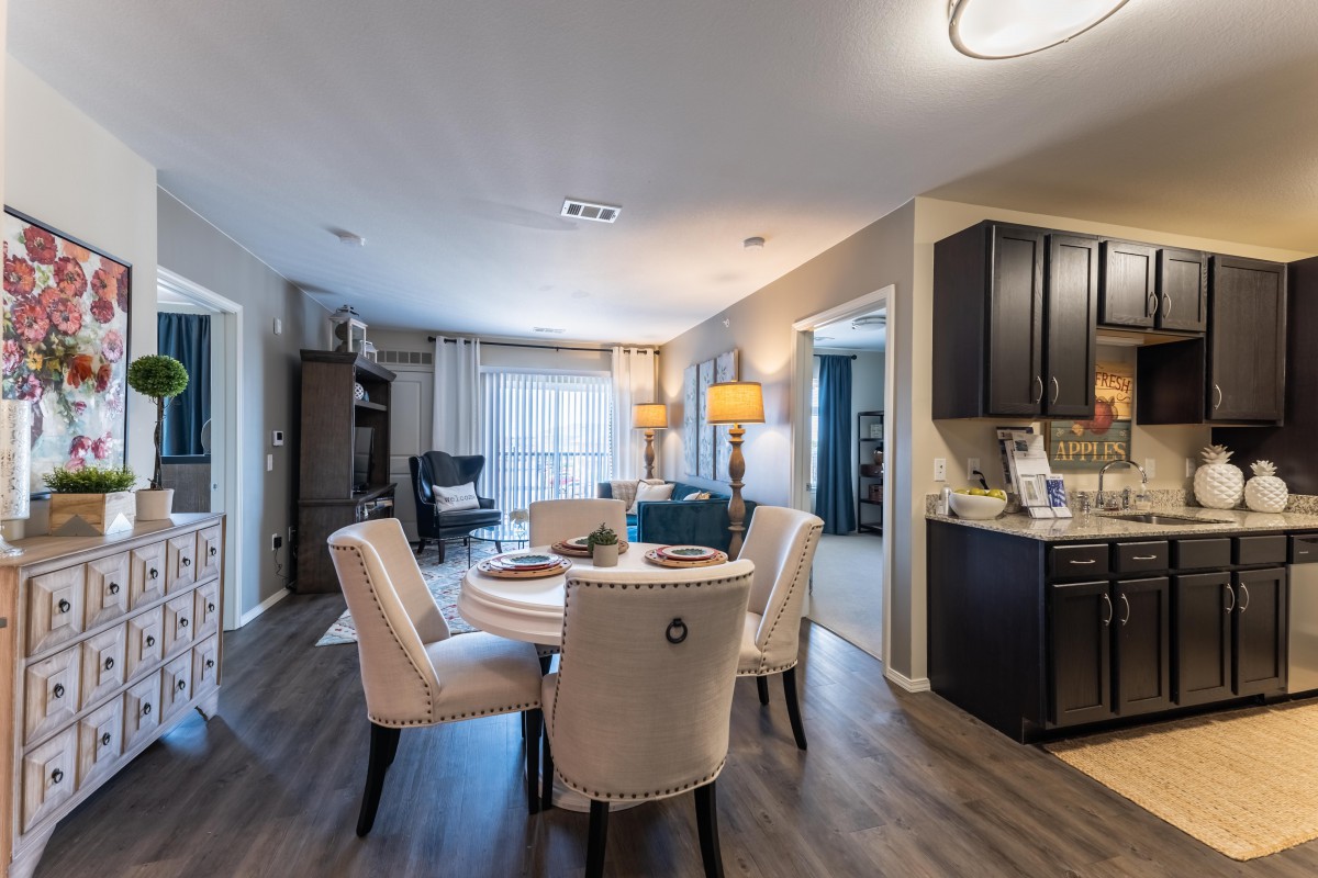A modern open floor plan featuring a dining and living area with stylish furniture and wood flooring.