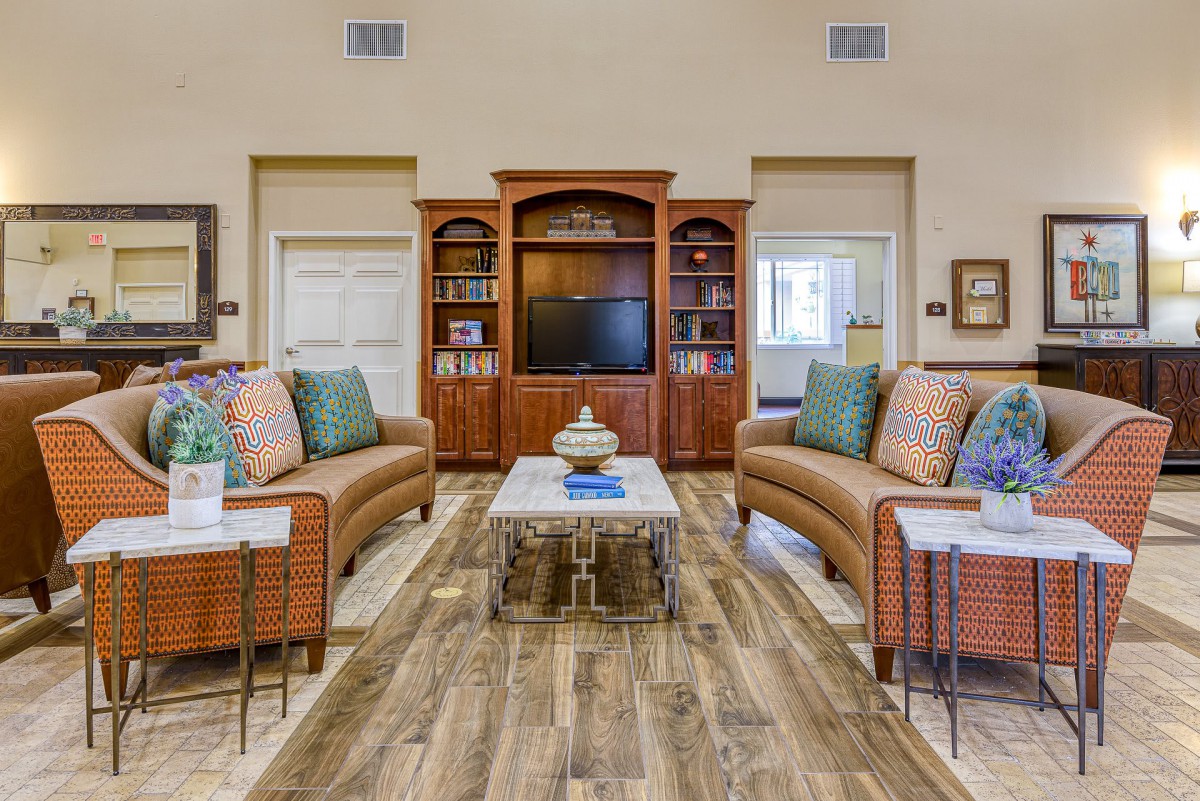 A cozy living room with matching sofas and an entertainment center.
