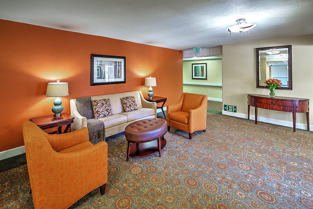 A cozy living room with orange accents and comfortable seating.