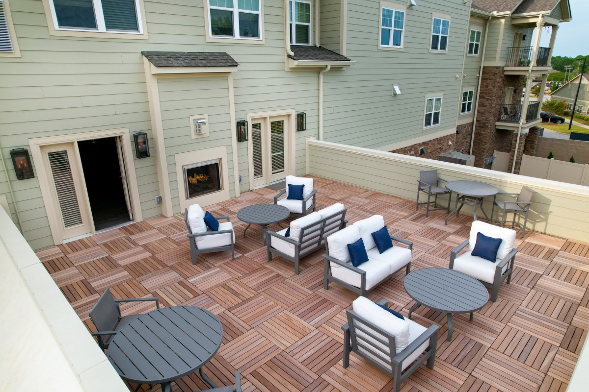 An inviting outdoor patio with modern furniture and a wooden deck.