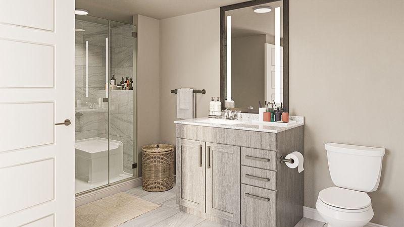 A modern bathroom featuring a sleek vanity and an illuminated mirror, with a glass-enclosed shower on the side.