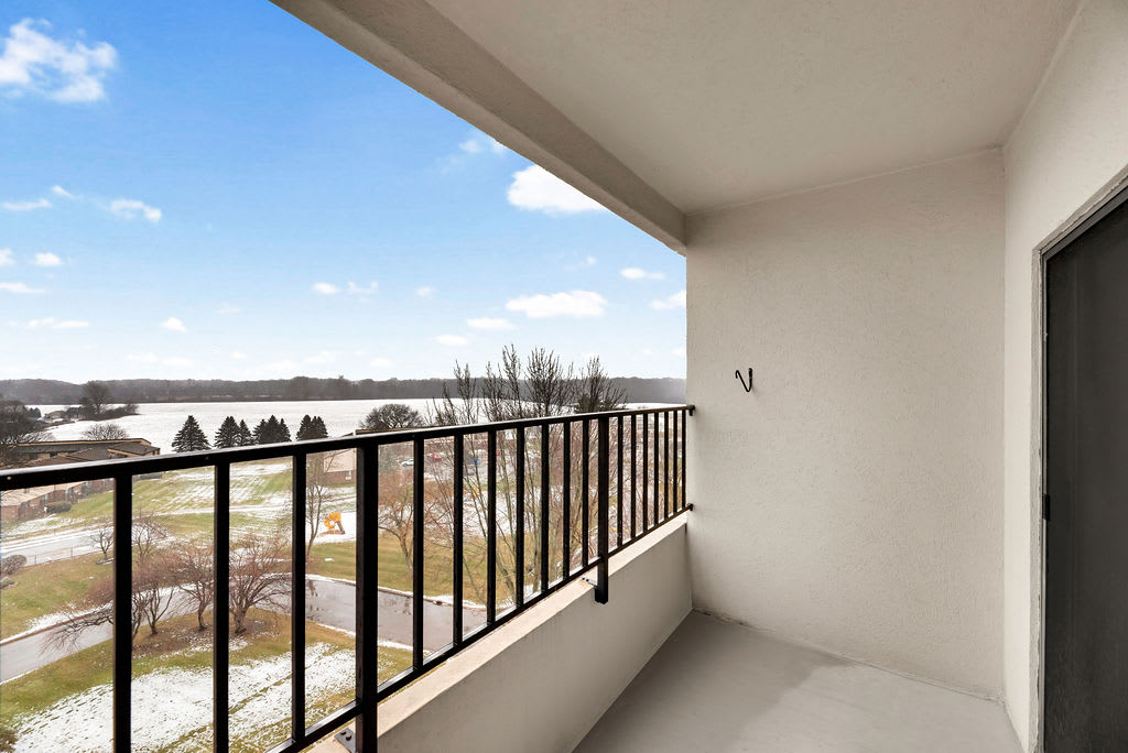 A spacious balcony overlooking a scenic view with clear skies and nature.