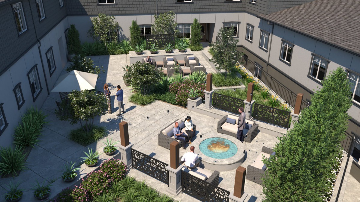 A beautifully landscaped courtyard with people socializing around a fountain and comfortable outdoor seating.