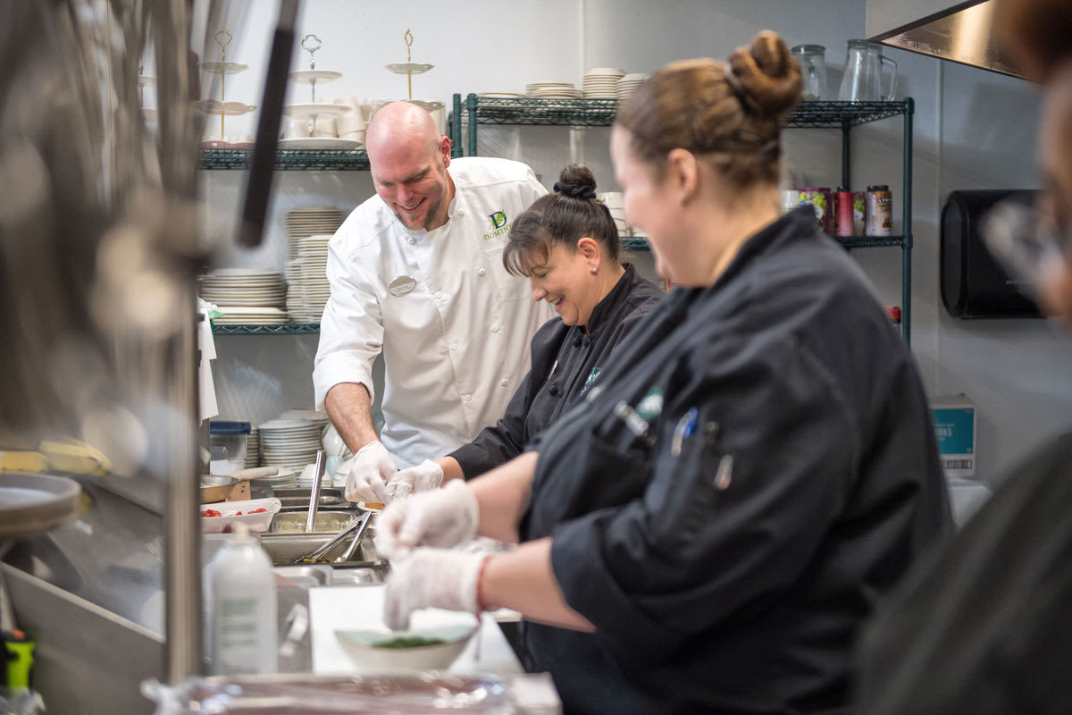 Chefs working together in a professional kitchen, preparing dishes with focus and teamwork.