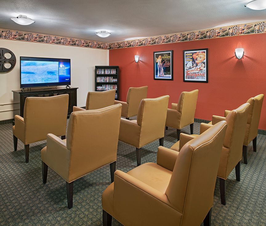 A cozy home theater room with comfortable seating and movie posters on the walls.