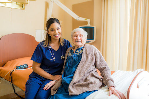 A compassionate nurse posing with an elderly patient in a hospital setting, highlighting the caring relationship in healthcare.