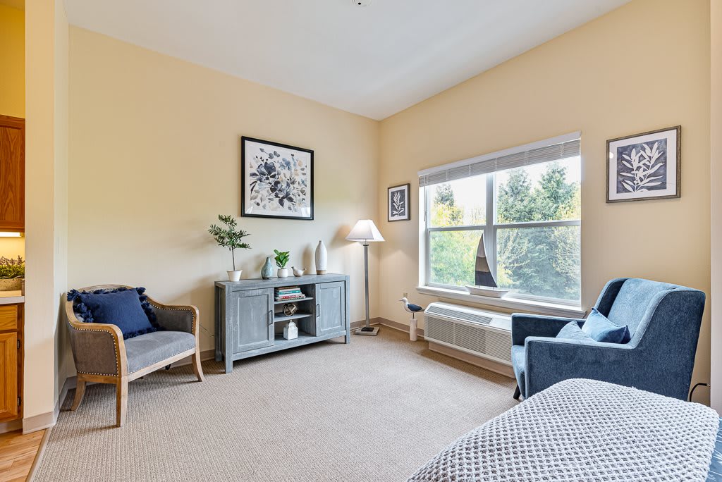 A cozy living room with comfortable seating, a large window, and tasteful decor.