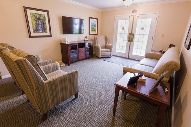 A cozy living room with comfortable seating and a television mounted on the wall.