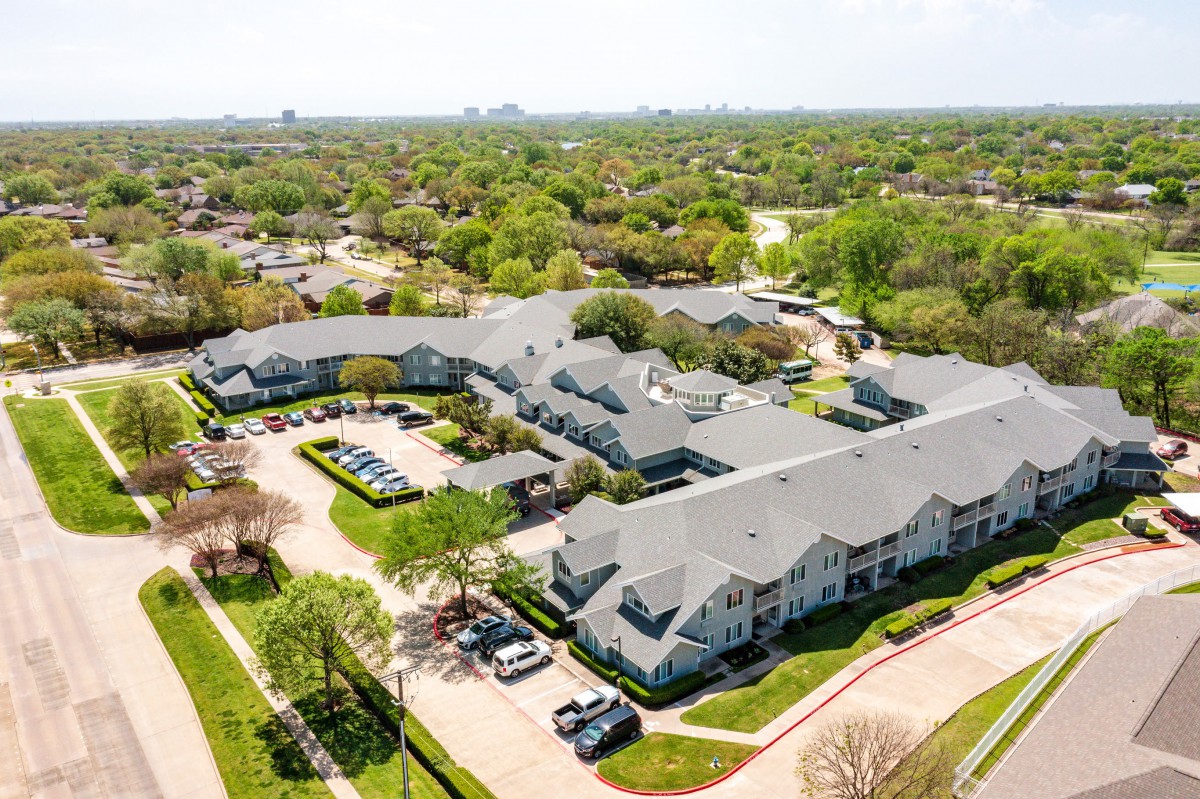 An aerial view of a residential apartment complex surrounded by greenery.