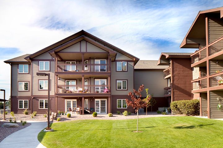 A modern apartment building with spacious balconies and a well-maintained lawn.
