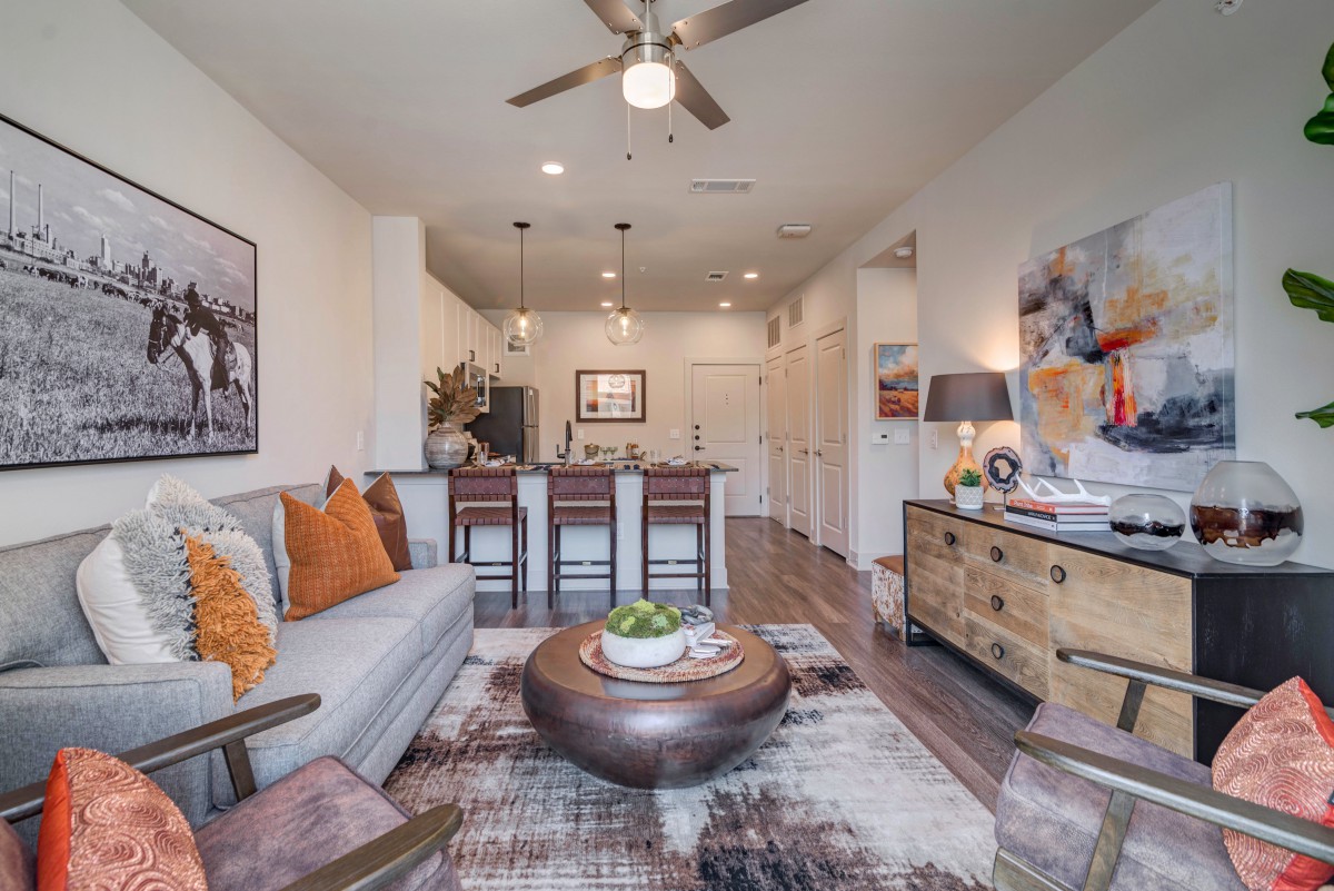 A modern apartment living room with stylish decor and an open kitchen layout.