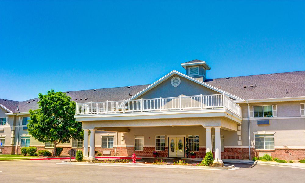 A sunny day view of a residential building with a prominent entrance and balcony.