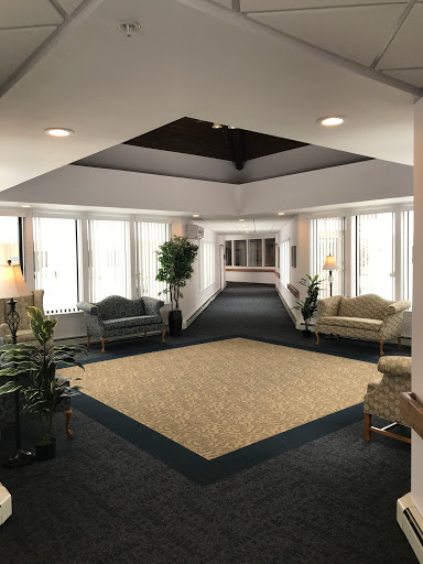 A spacious and well-lit lobby area featuring comfortable seating and plants.
