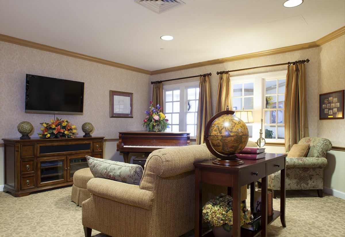 A cozy living room with elegant furnishings including a sofa, globe, and a television.