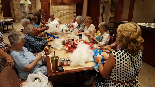A group of women engaged in a crafting session, working together to create stuffed toys.