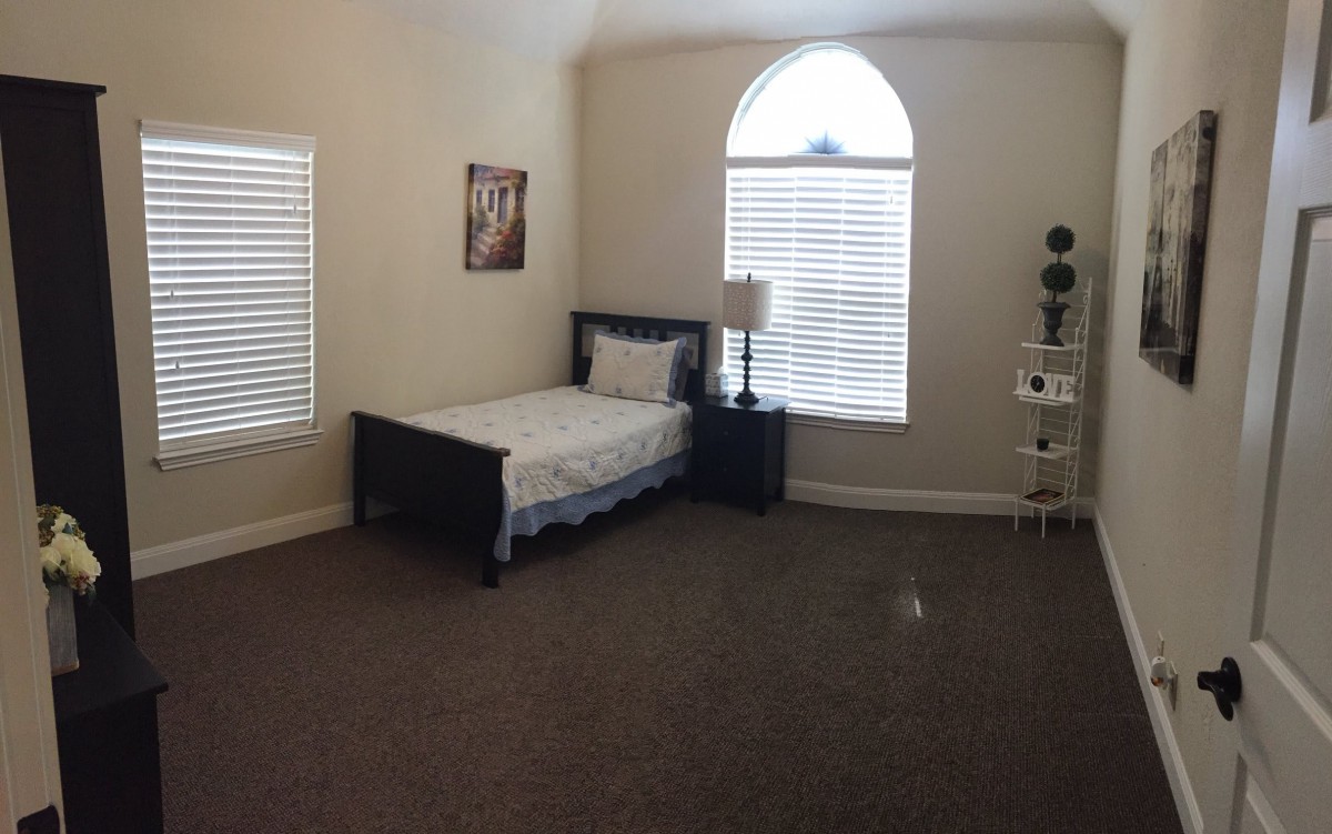 A minimalist bedroom with a single bed and large windows.