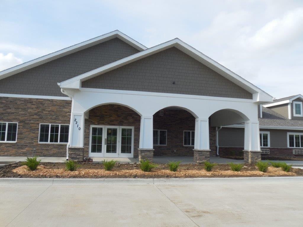 A commercial building with a prominent arched entrance and landscaped front area.