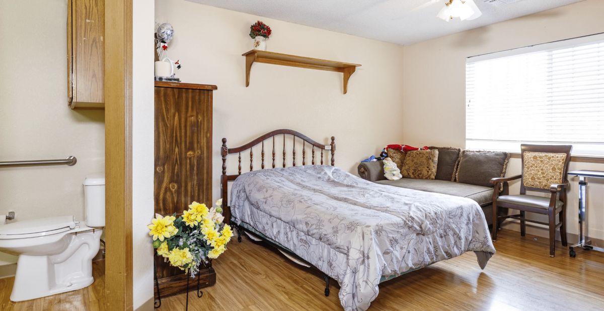 A cozy bedroom with a bed, sofa, and decorative elements.