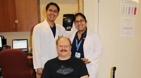 Group photo of medical professionals with a smiling patient.