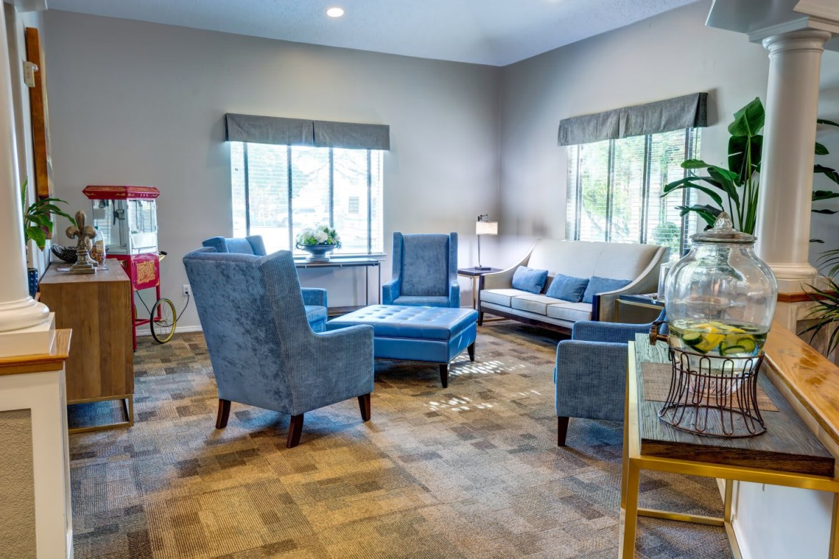 A cozy living room with blue upholstered furniture and large windows.