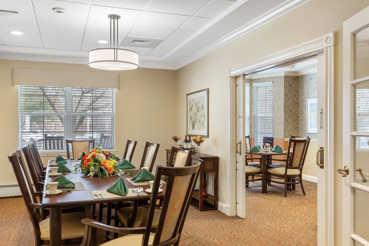 An elegantly decorated dining room with a large table and chairs, set for a meal.