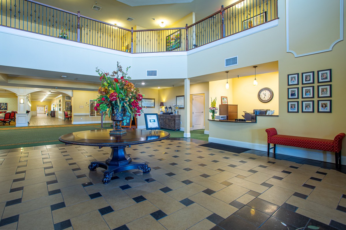 A spacious hotel lobby with a reception desk and decorative elements.