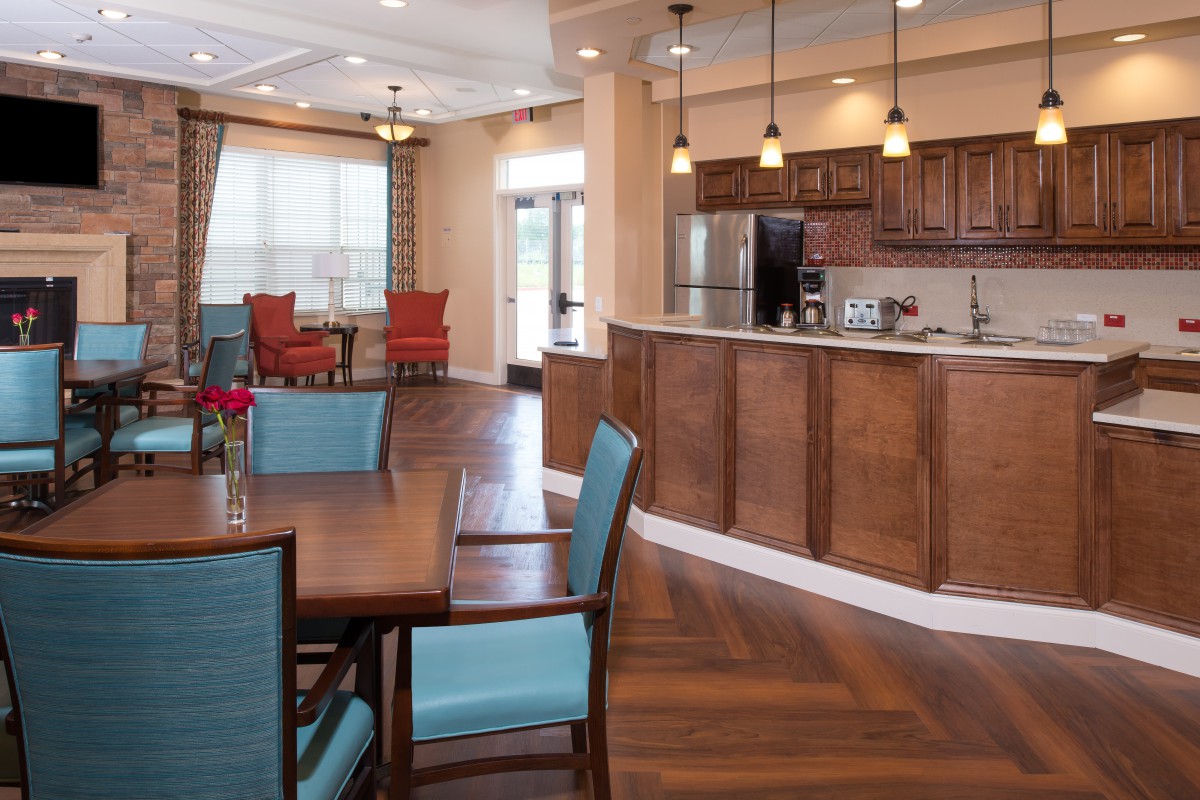 A modern open-concept kitchen and dining area featuring wood flooring and stylish pendant lighting.