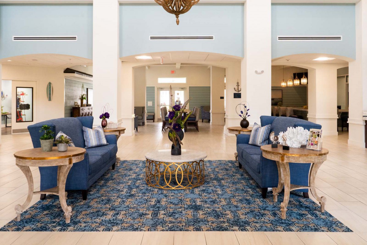 A well-decorated lobby with sofas, a central table, and an ornate rug.