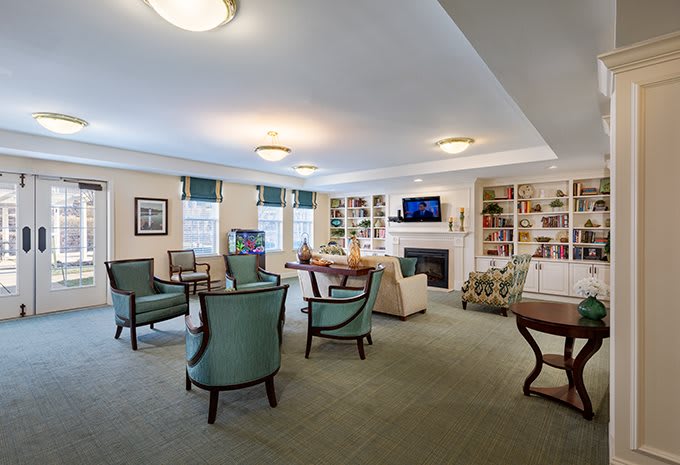 A cozy living room area with comfortable seating, bookshelves, and a television.