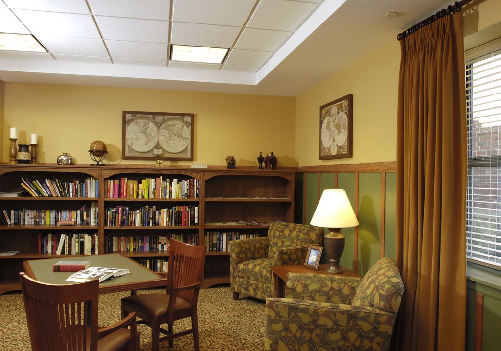A cozy library corner with a seating area and bookshelves.